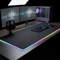 Extra-large RGB gaming mouse pad with glowing LED edge lighting on a dark desk
